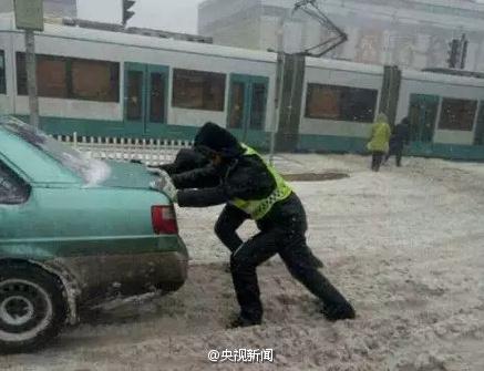 交警雪中推车跪在马路上休息 