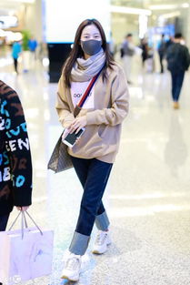 王媛可穿驼色卫衣搭配牛仔裤现身机场,戴着口罩也能看到她在笑