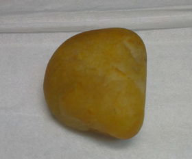 一直不知道手里这个石头是什么种类的,算不算是黄玉呢 还是一般的石头,请各位朋友帮忙鉴定一下 