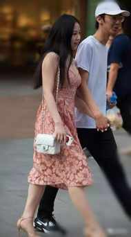美丽的连衣裙姑娘,挽着男朋友的手走在街上是一件幸福的事