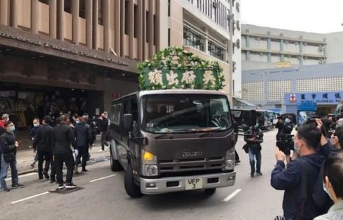 吴孟达出殡 遗体被众人抬上黑色灵车,小儿子手捧遗像满面悲伤