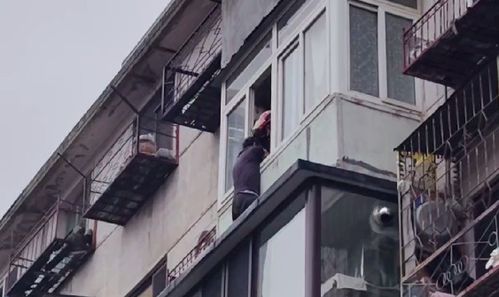 老人被困5楼阳台外消防公安联手将其救回