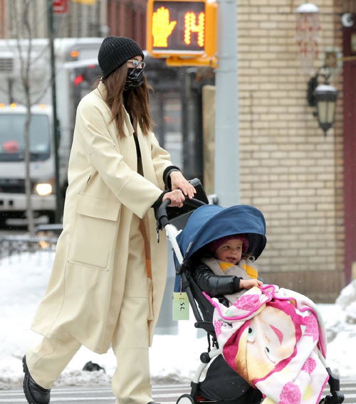 伊莉娜 莎伊克穿米白色大衣推女儿上街,高贵迷人,好有超模范