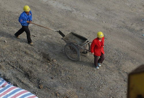 建筑工地上的女工人 推着砂浆车,举着钢筋,满脸是汗