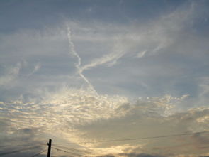 请问一下这图片上天空上的一条线是云还是什么东西落下或飞上天 