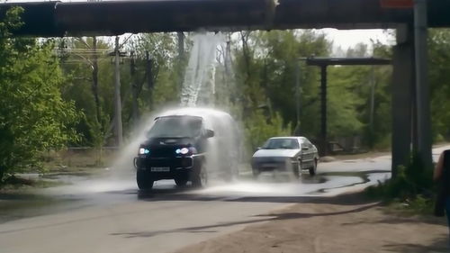 路上的水管破了,过往车辆都往水下开,只为能免费洗车 