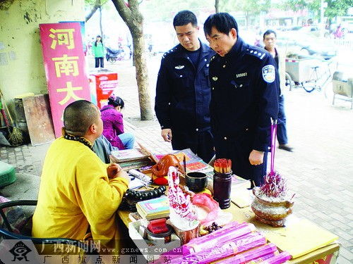 男子穿袈裟闹市区摆摊 算命 闲时西装革履叼烟卷