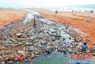 受近日雨水影响 一浴沙滩出现大量裸露石头 