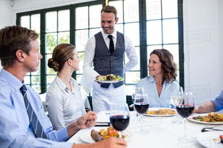 Waiter serving salad to the business people in restaurant Stock ... 